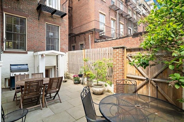 a view of a patio with table and chairs and potted plants