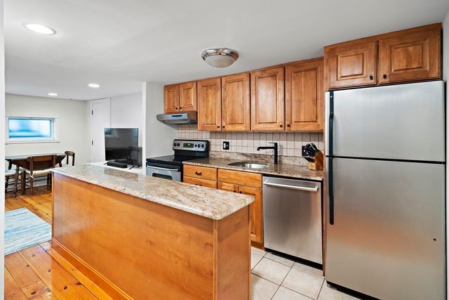 a kitchen with stainless steel appliances granite countertop a refrigerator stove top oven a sink and dishwasher