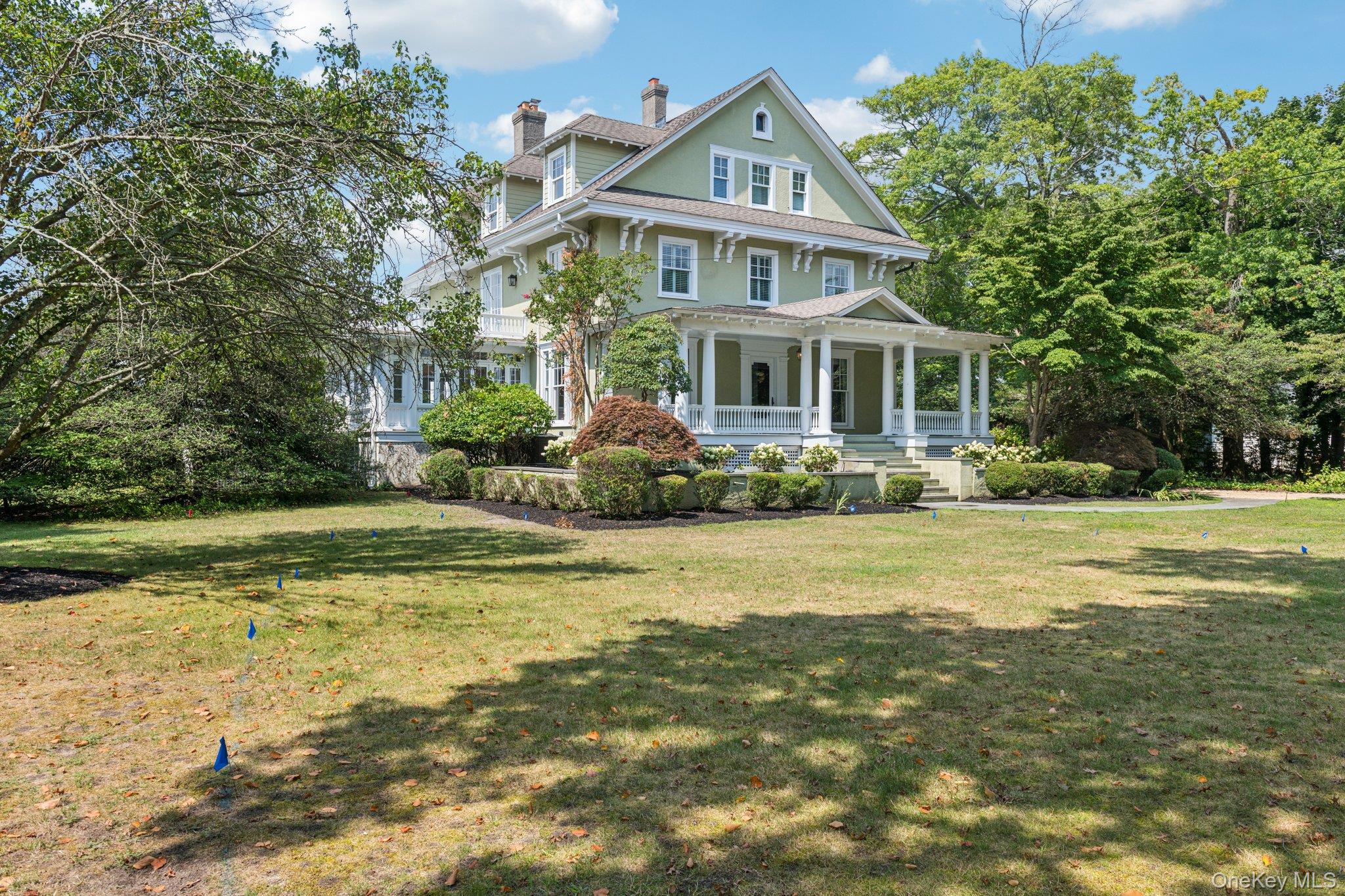 Victorian-style house featuring covered porch, a chimney, and a front lawn