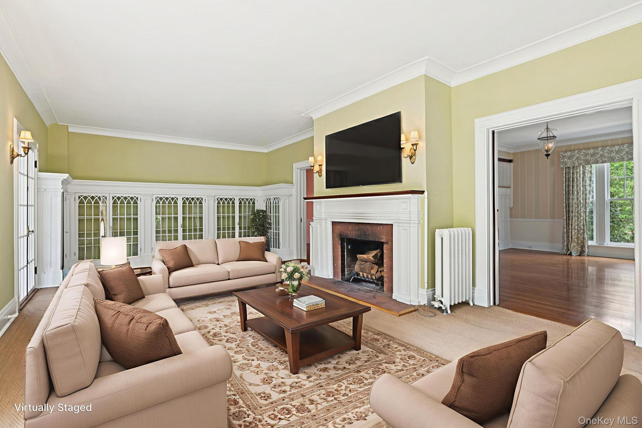 90 Thompson Avenue Babylon, NY 11702 - Photo 13 of 35 Living area with ornamental molding, a brick fireplace, radiator, and wood finished floors