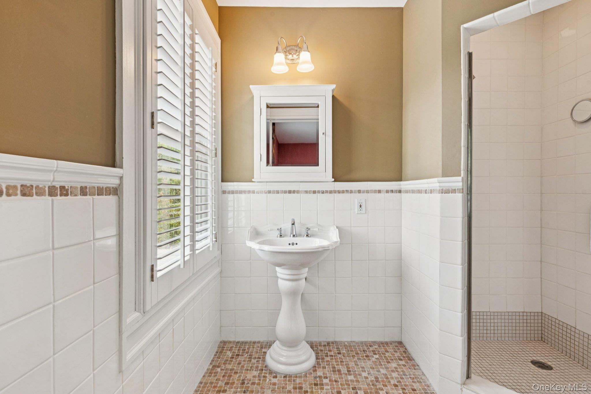 90 Thompson Avenue Babylon, NY 11702 - Photo 16 of 35 Bathroom with tile walls, a shower stall, a wainscoted wall, and tile patterned floors