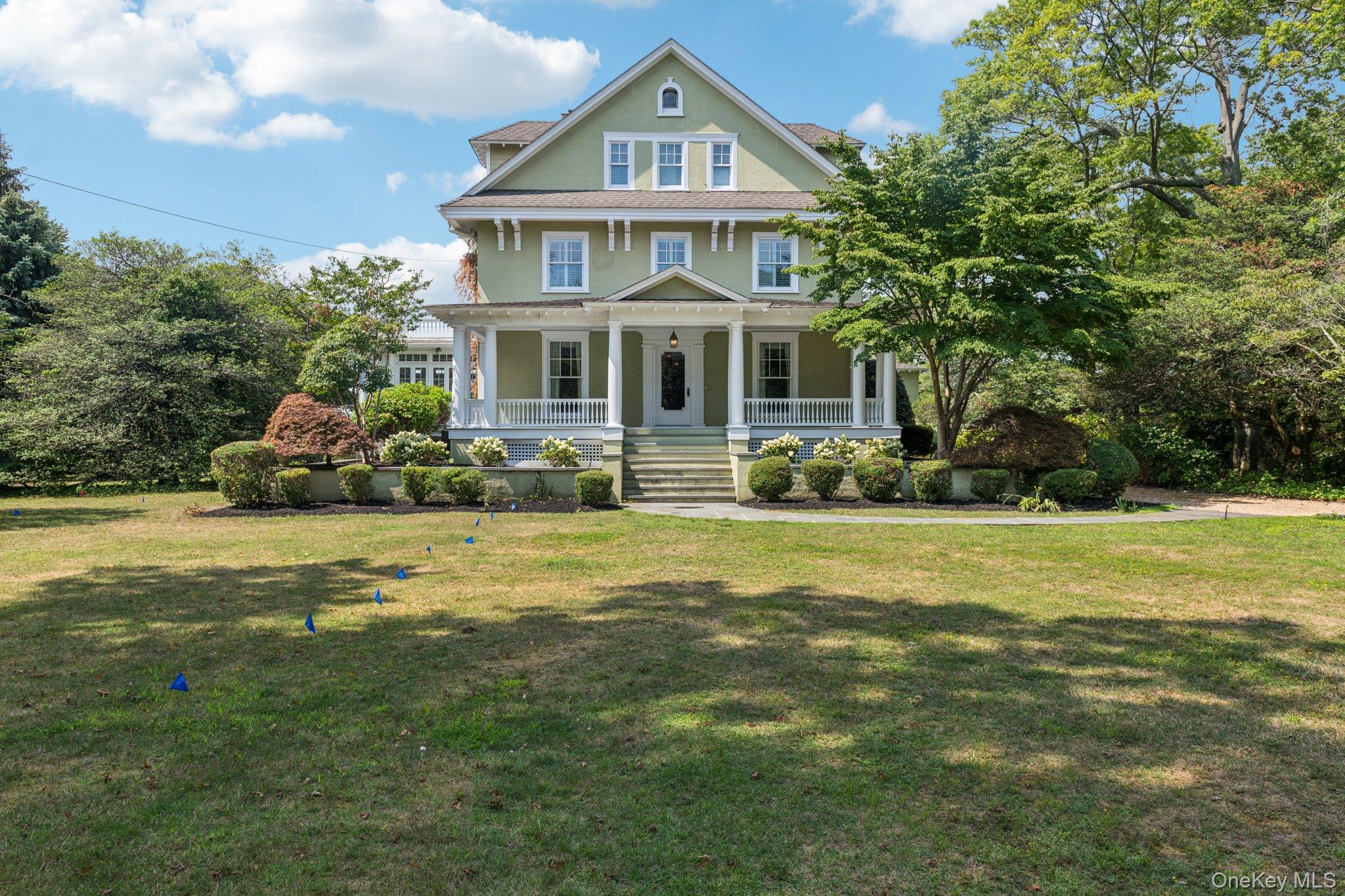 90 Thompson Avenue Babylon, NY 11702 - Photo 2 of 35 View of front facade with covered porch, a front yard, and stucco siding