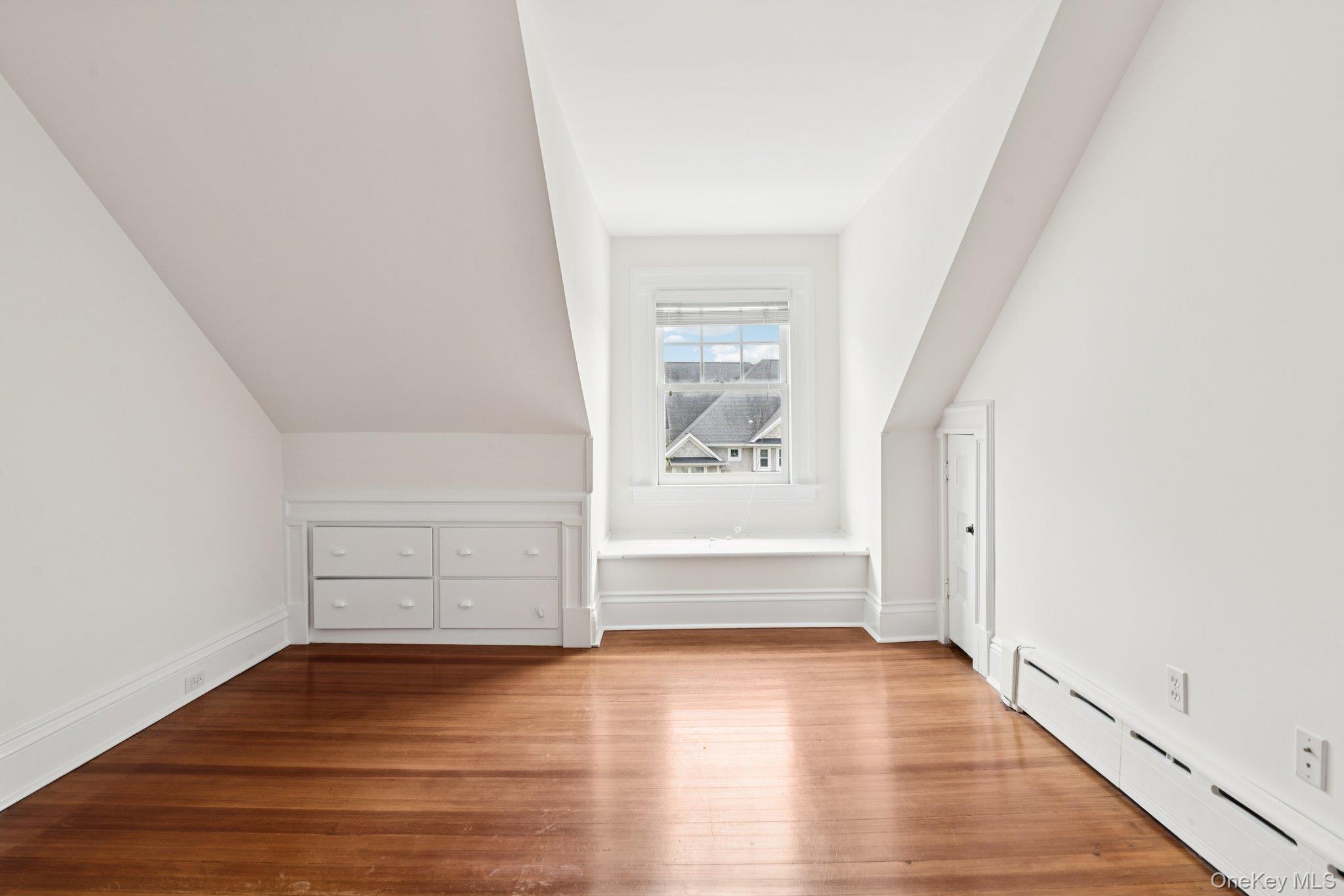 90 Thompson Avenue Babylon, NY 11702 - Photo 26 of 35 Additional living space with a baseboard heating unit and wood finished floors