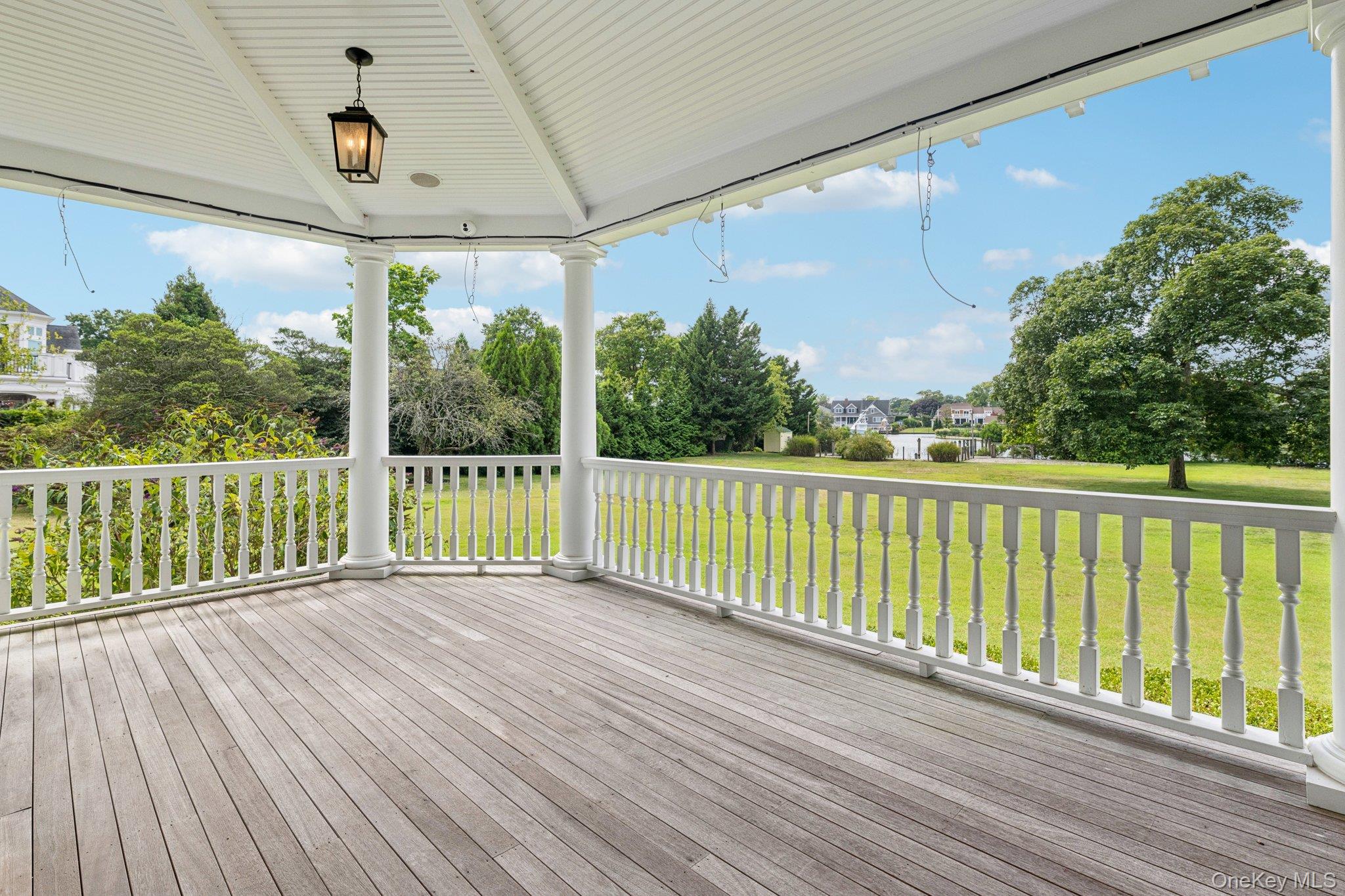 90 Thompson Avenue Babylon, NY 11702 - Photo 31 of 35 Wooden terrace featuring a lawn and view of scattered trees