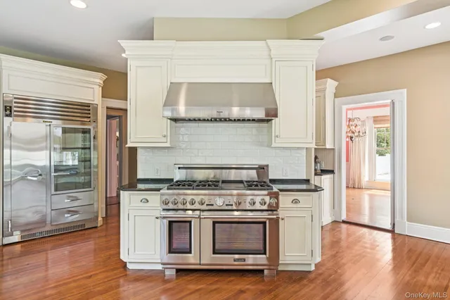 a kitchen with granite countertop a stove and a wooden floors