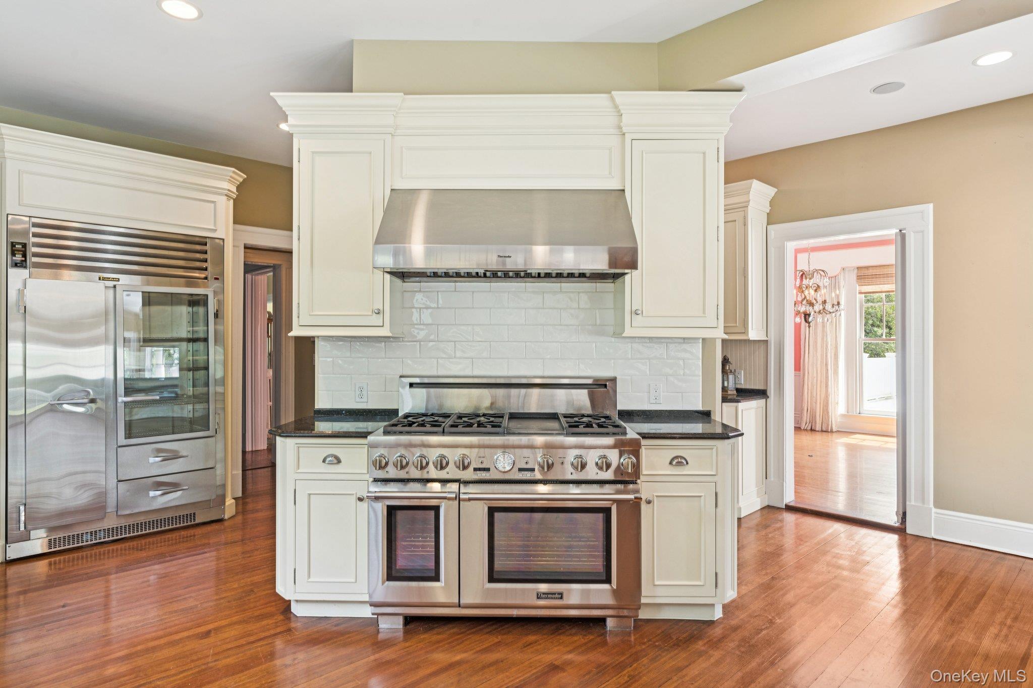 90 Thompson Avenue Babylon, NY 11702 - Photo 9 of 35 Kitchen featuring recessed lighting, premium appliances, exhaust hood, backsplash, and dark wood finished floors