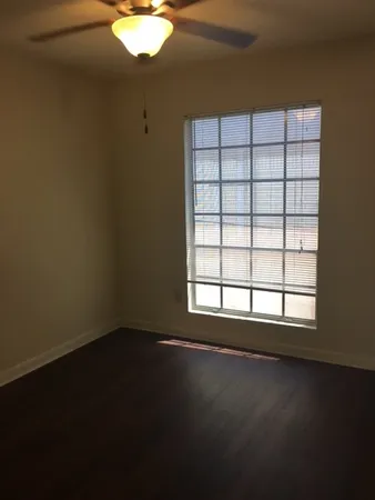 a view of a livingroom with wooden floor and a window