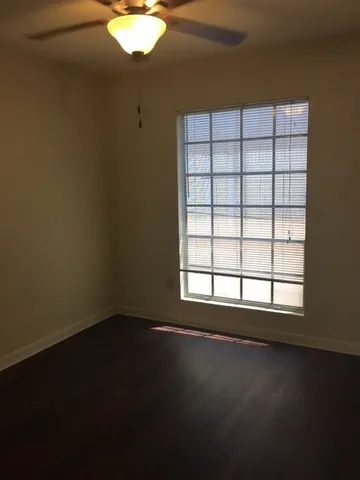 a view of a livingroom with wooden floor and a window