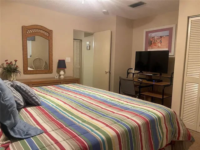 a bedroom with a bed and a potted plant