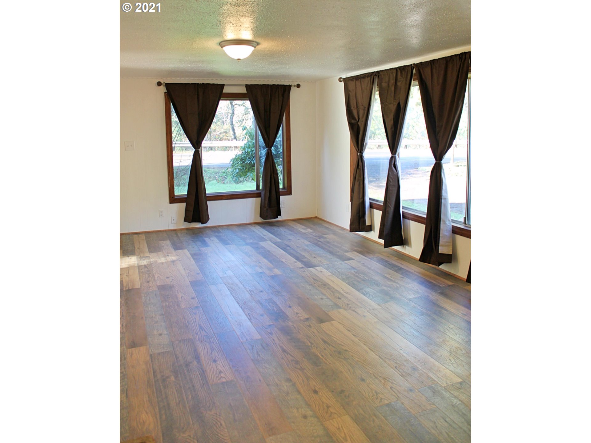 37877 Row River Road Dorena, OR 97434 - Photo 4 of 18 a view of an empty room with wooden floor and a window