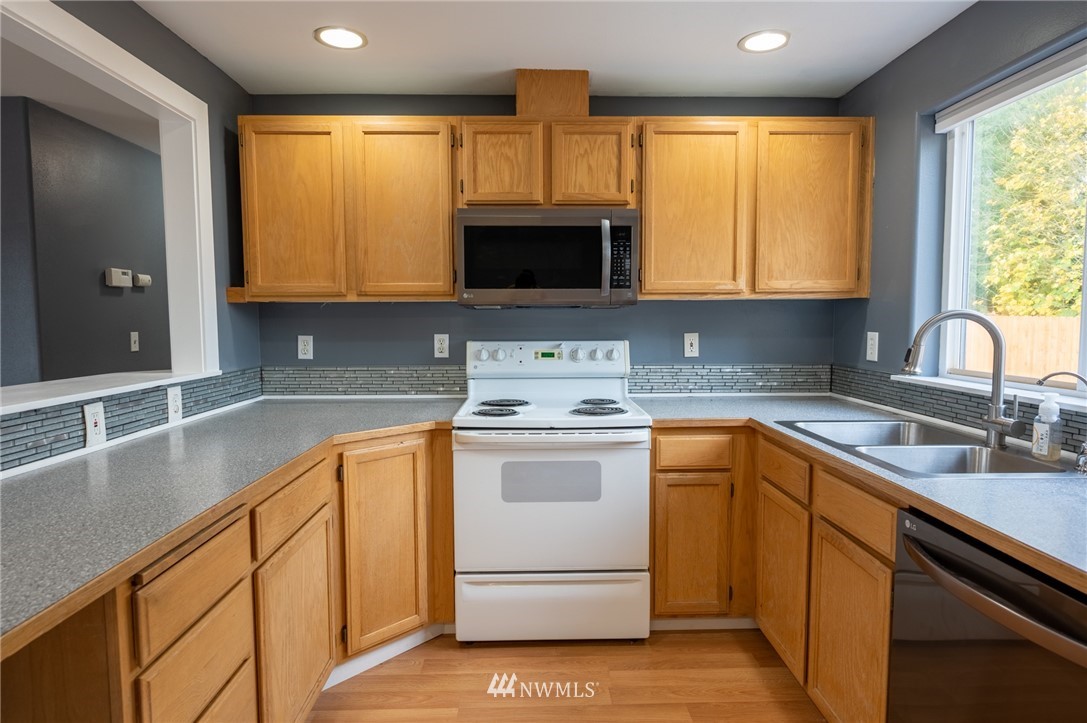 427 Rohrer Loop Sedro-Woolley, WA 98284 - Photo 11 of 36 a kitchen with stainless steel appliances granite countertop a sink a stove and cabinets