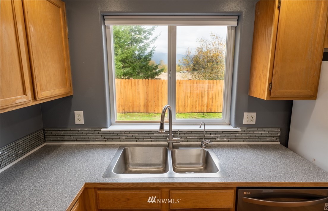 427 Rohrer Loop Sedro-Woolley, WA 98284 - Photo 12 of 36 a kitchen with granite countertop a sink window and cabinets