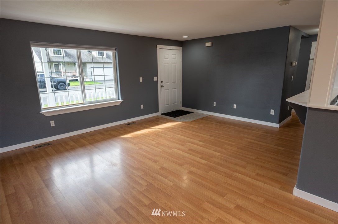 427 Rohrer Loop Sedro-Woolley, WA 98284 - Photo 6 of 36 a view of an empty room with wooden floor and a window