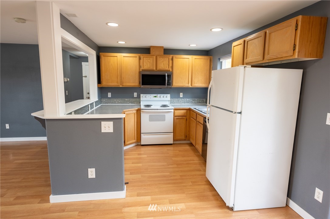 427 Rohrer Loop Sedro-Woolley, WA 98284 - Photo 9 of 36 a kitchen with stainless steel appliances granite countertop a refrigerator a sink a stove and a microwave
