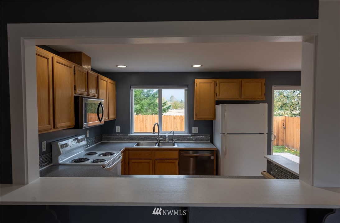 427 Rohrer Loop Sedro-Woolley, WA 98284 - Photo 10 of 36 a kitchen with stainless steel appliances granite countertop a refrigerator a sink a stove a microwave and island