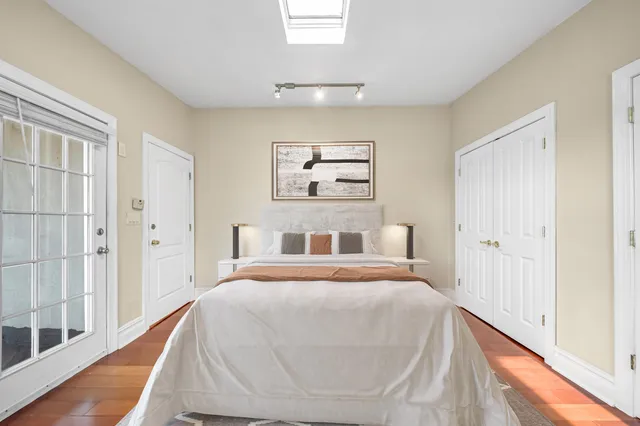 a bedroom with a bed and a painting on the wall