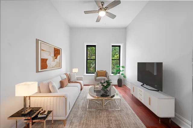 a living room with furniture a flat screen tv and a window