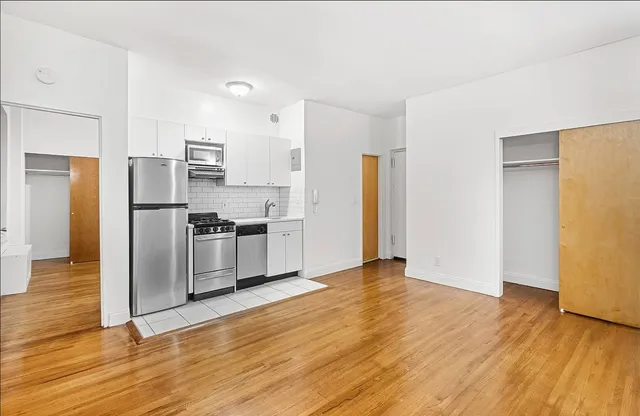 a view of kitchen view wooden floors appliances and cabinets