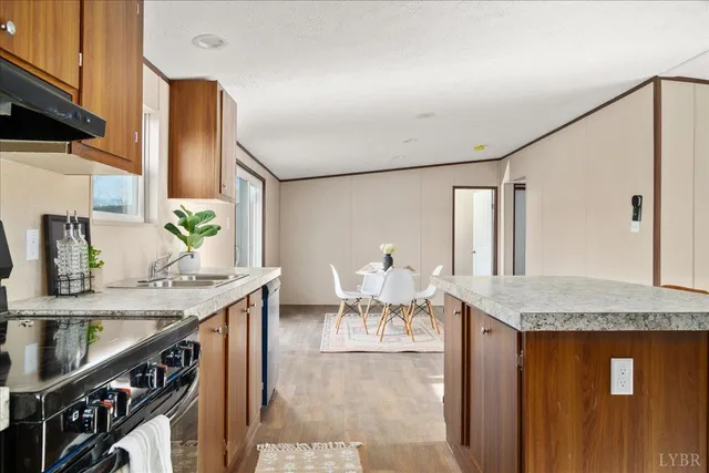 a kitchen view with granite countertop a sink chairs and stove