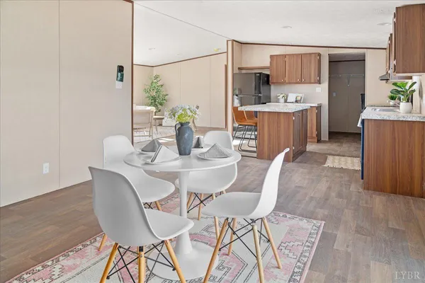 a view of a dining room with furniture and a kitchen view