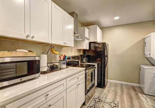 a kitchen with stainless steel appliances granite countertop a stove a refrigerator and a microwave