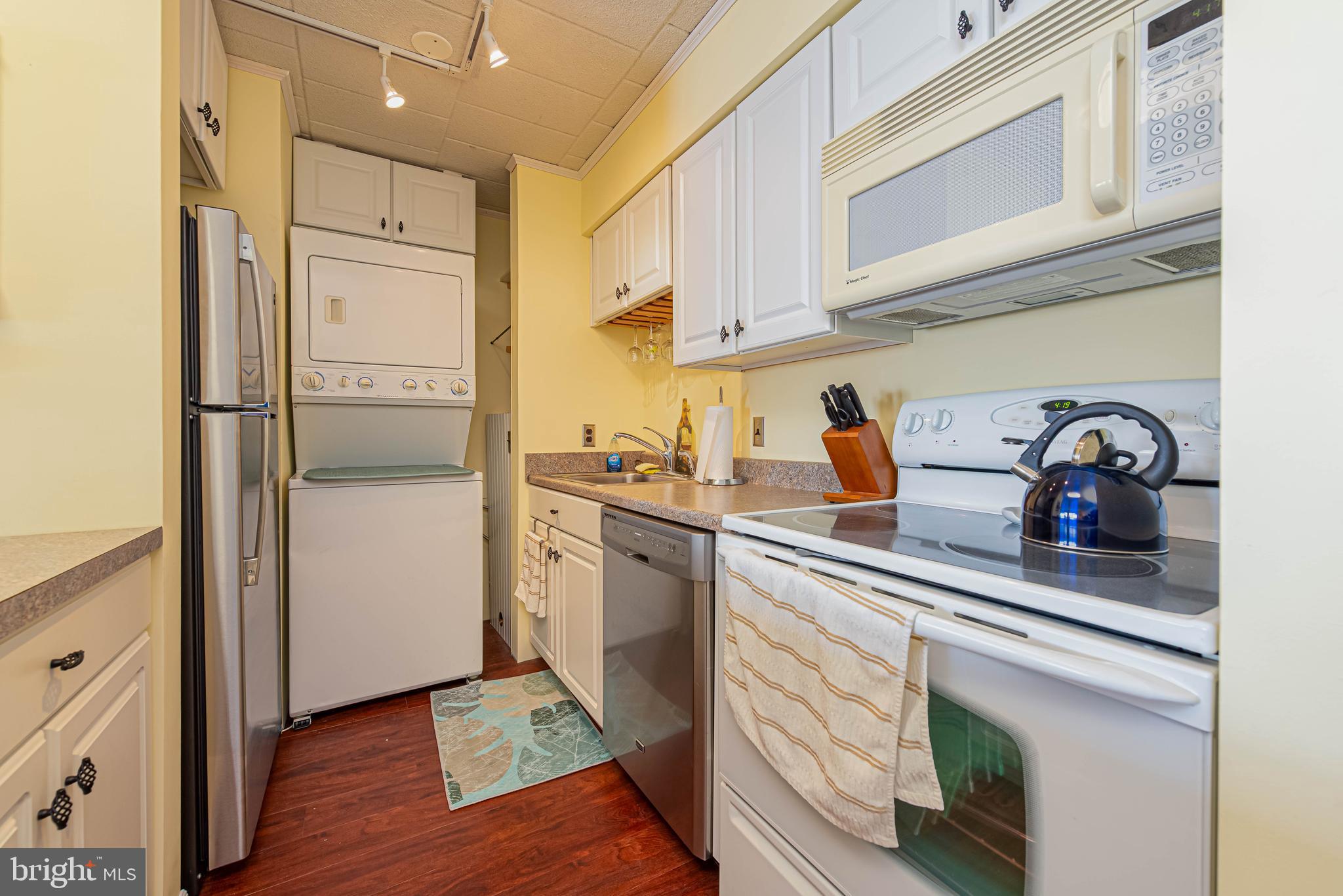 745 Mooring Road, Unit 406 Ocean City, MD 21842 - Photo 12 of 24 a kitchen with a refrigerator and cabinets