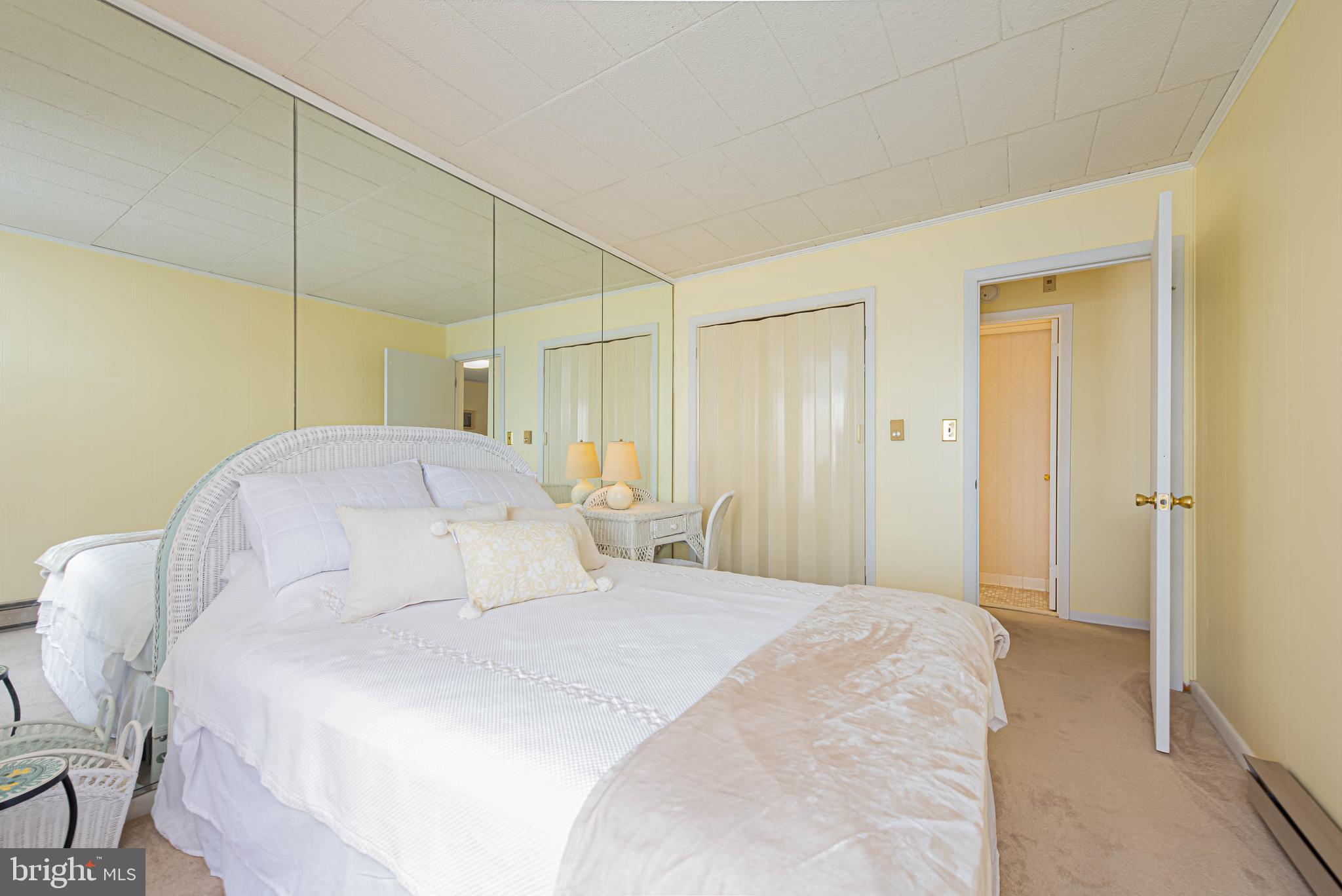 745 Mooring Road, Unit 406 Ocean City, MD 21842 - Photo 15 of 24 a bedroom with a bed a table and painting