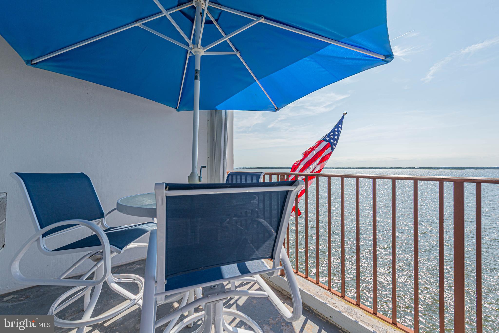 745 Mooring Road, Unit 406 Ocean City, MD 21842 - Photo 18 of 24 a view of a balcony with chairs and an umbrella