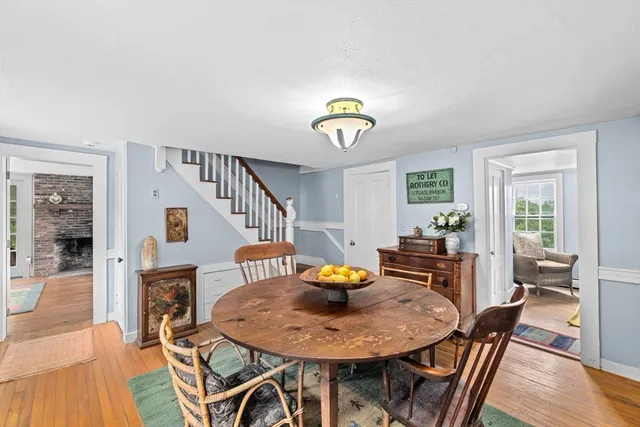 a view of a dining room with furniture a potted plant and wooden floor