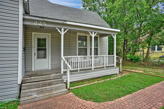 a view of a house with a small yard and wooden fence