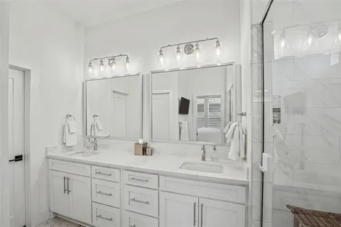 a bathroom with double vanity sinks and a mirror