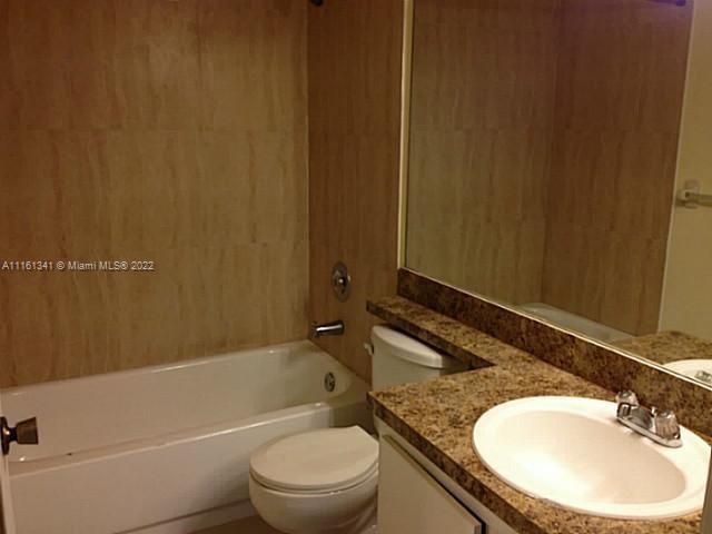 610 South Park Road, Unit 111 Hollywood, FL 33021 - Photo 4 of 7 a bathroom with a granite countertop sink toilet and shower