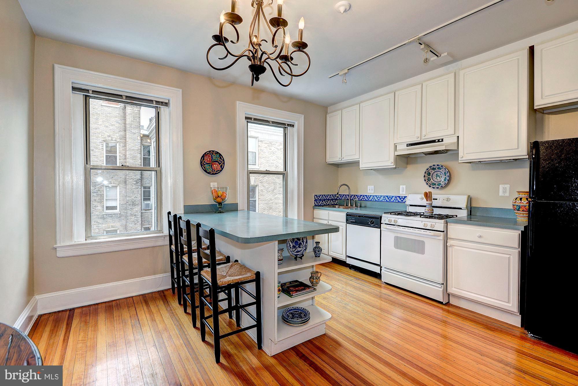 2022 Columbia Road Northwest, Unit 612 Washington, DC 20009 - Photo 12 of 29 a kitchen with stainless steel appliances granite countertop a white cabinets and wooden floor
