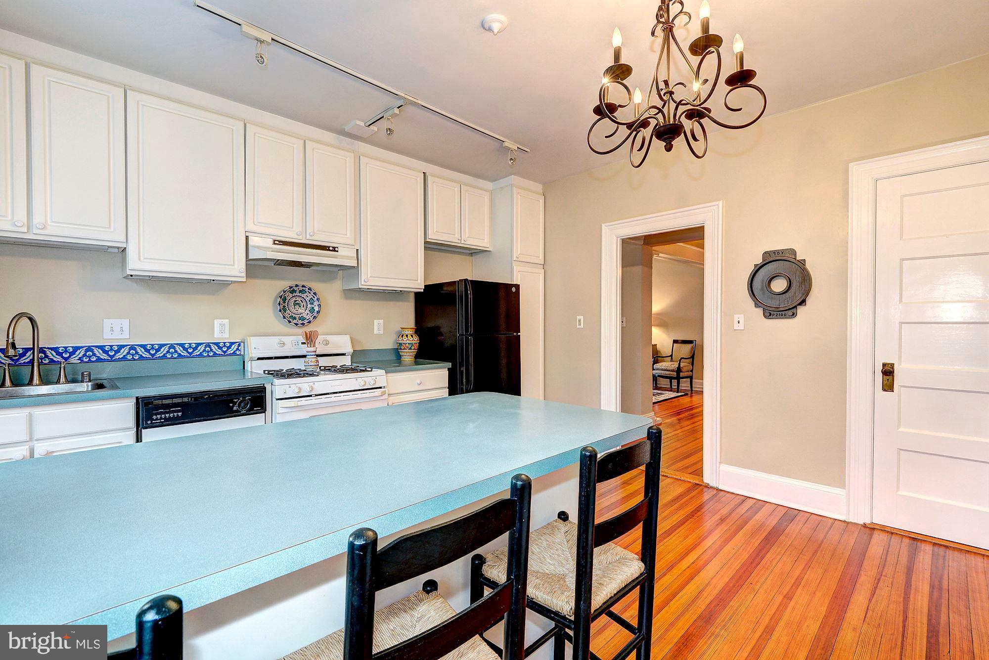 2022 Columbia Road Northwest, Unit 612 Washington, DC 20009 - Photo 13 of 29 a kitchen with stainless steel appliances a white cabinets wooden floors and a sink