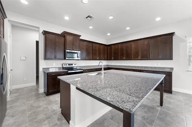 a kitchen with stainless steel appliances granite countertop a sink dishwasher and refrigerator