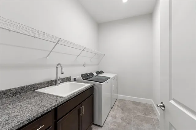 a bathroom with a granite countertop sink and washing machine