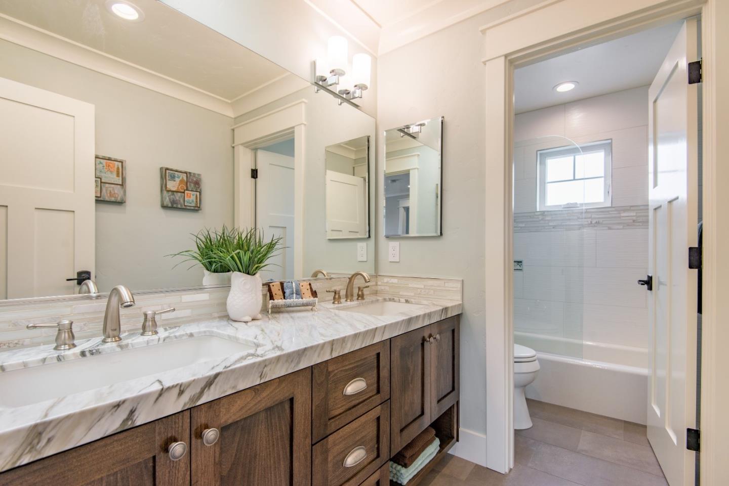 10416 Prune Tree Lane Cupertino, CA 95014 - Photo 18 of 21 a bathroom with a granite countertop sink double vanity and a mirror