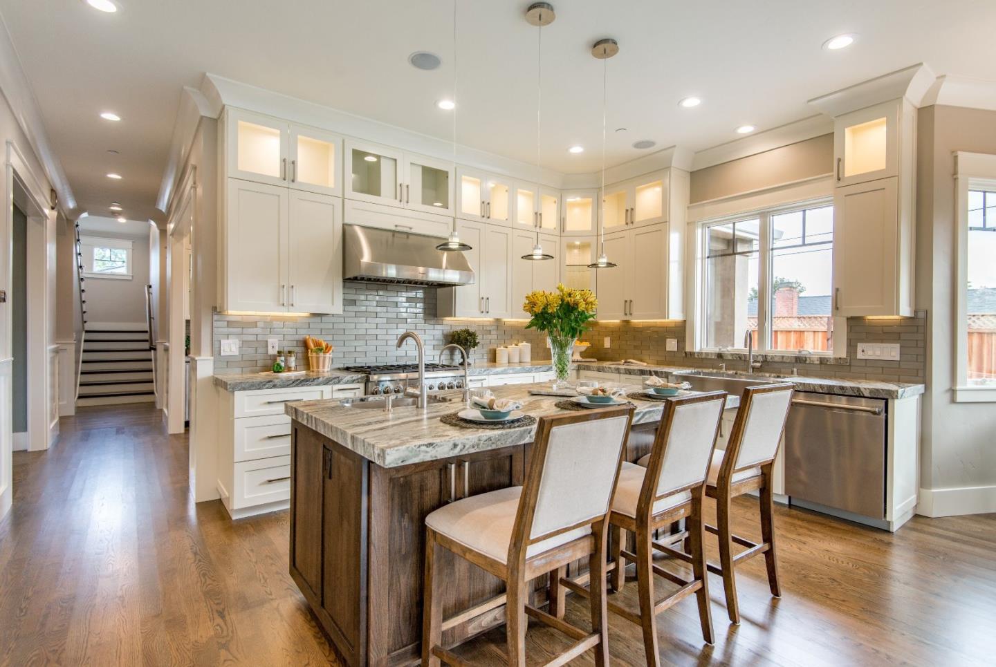 10416 Prune Tree Lane Cupertino, CA 95014 - Photo 4 of 21 a kitchen with stainless steel appliances granite countertop a stove top oven a sink dishwasher a dining table and chairs with wooden floor