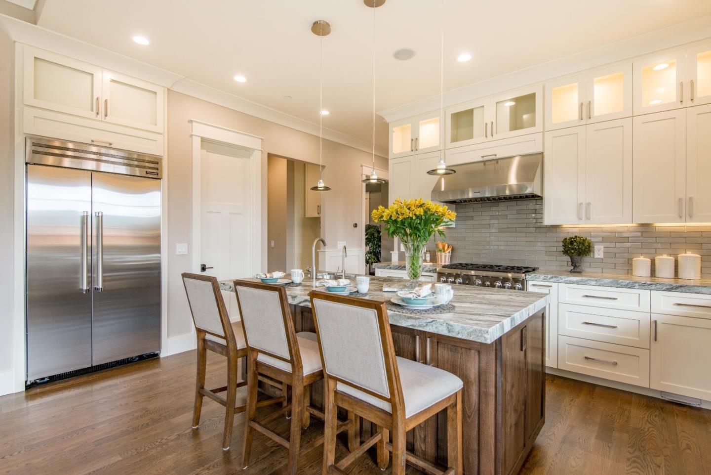 10416 Prune Tree Lane Cupertino, CA 95014 - Photo 5 of 21 a kitchen with stainless steel appliances granite countertop a kitchen island a stove a table and a refrigerator