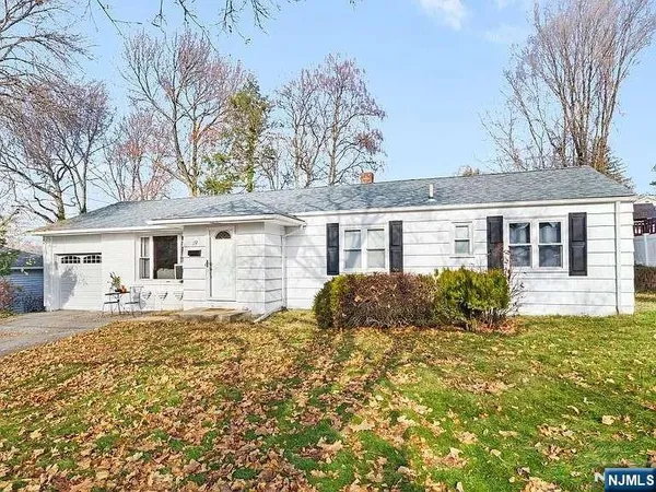 a front view of house with yard and trees in the background