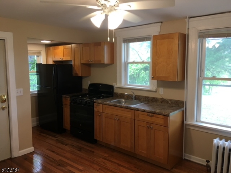 49 Wertsville Road, Unit C Hillsborough, NJ 08844 - Photo 4 of 19 a kitchen with stainless steel appliances granite countertop a refrigerator a sink dishwasher a stove and a dining table with wooden floor