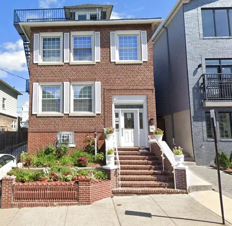 a front view of a house with a garden