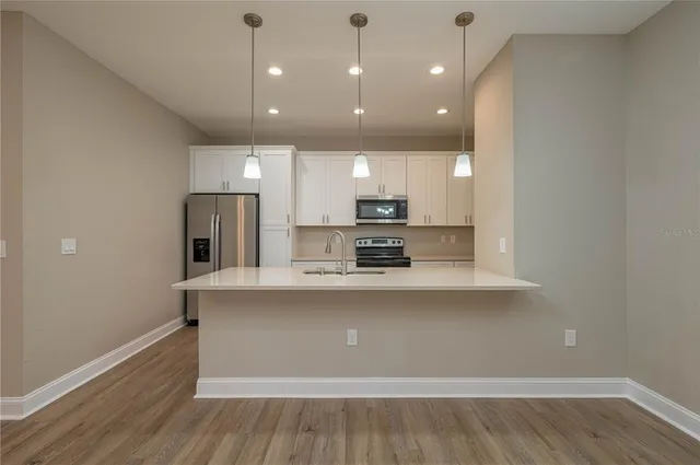 a large kitchen with kitchen island a sink stainless steel appliances and cabinets