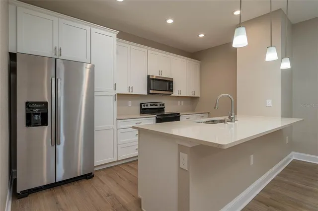 a kitchen with stainless steel appliances a refrigerator sink and microwave