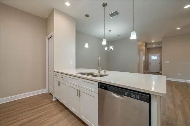 a kitchen with a sink a mirror and wooden floor
