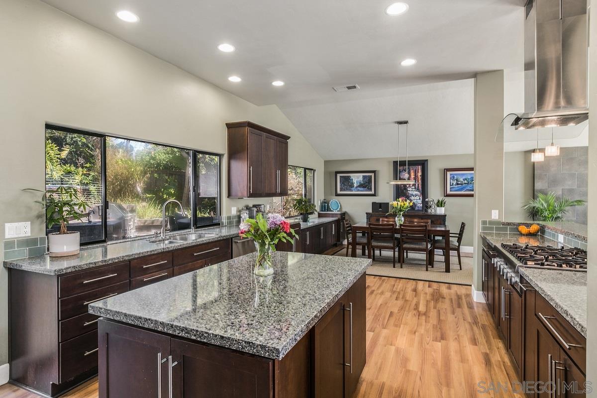 a kitchen with stainless steel appliances granite countertop sink stove and wooden cabinets