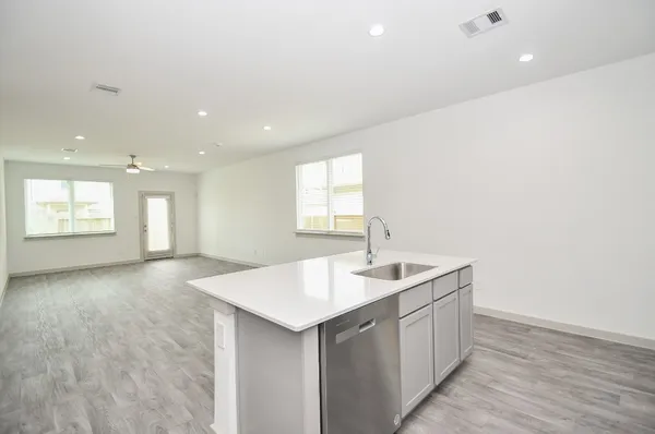 a view of kitchen island a sink wooden floor and window