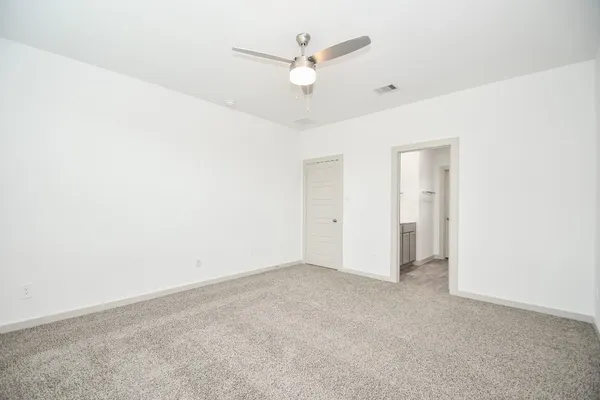 an empty room with closet and ceiling fan