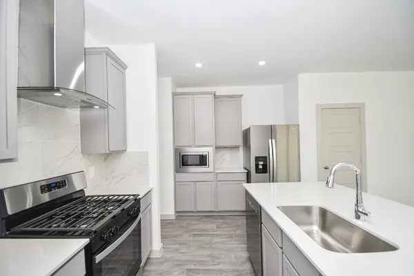 a kitchen with stainless steel appliances granite countertop a sink stove and refrigerator