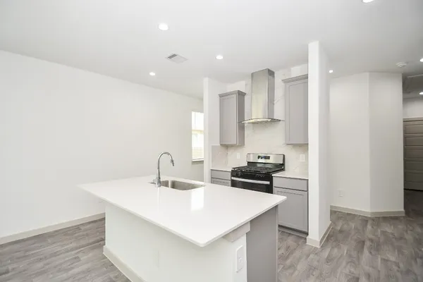 a kitchen with stainless steel appliances a sink stove and cabinets